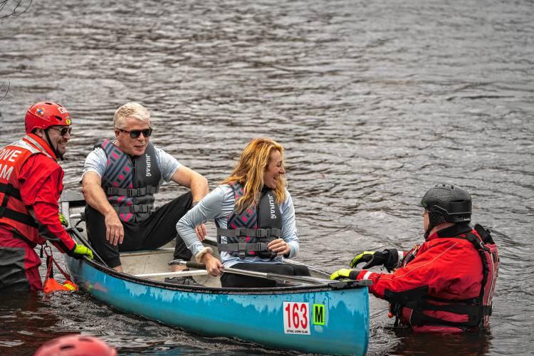 Jillian Valley and Michael Griffin are assisted out of their canoe on Saturday after completing the 59th running of the River Rat Race from Athol to Orange.