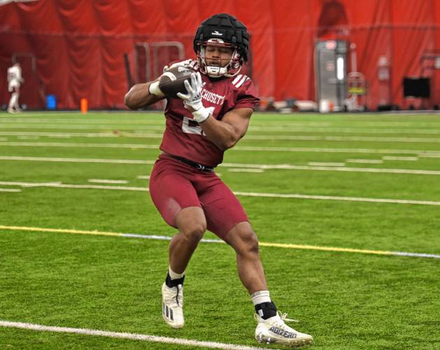 UMass redshirt junior running back Jalen John catches a pass from an assistant coach during the Minutemen’s first spring practice of the season on Tuesday morning in Amherst.
