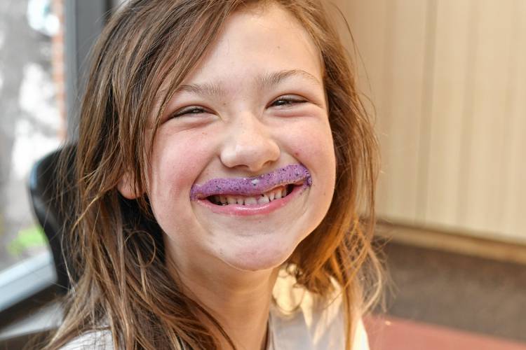 Amy Reynolds, 10, of Greenfield, sports a blueberry mango mustache during a smoothie-making class at the Greenfield Public Library on Tuesday.