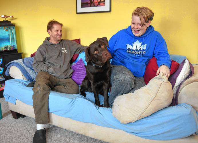Chris Sanborn with his son Rain and emotional support dog, Zeal, in their Greenfield home.