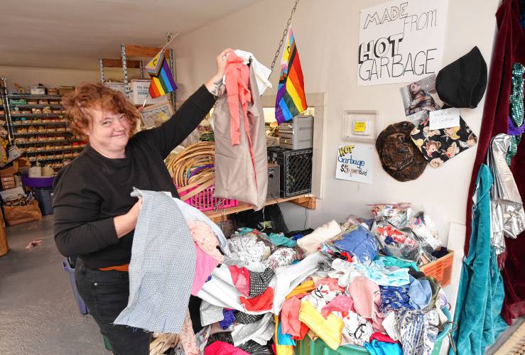 Shop manager Marlene Lavelle with donated fabrics and some items made from scraps at The Stash House in Turners Falls.