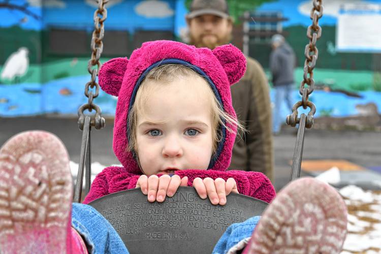 Sadie, 2½, hangs on as she is pushed on the swing by her father, Riley Baker, of Colrain, at Unity Park in Turners Falls on Friday afternoon.