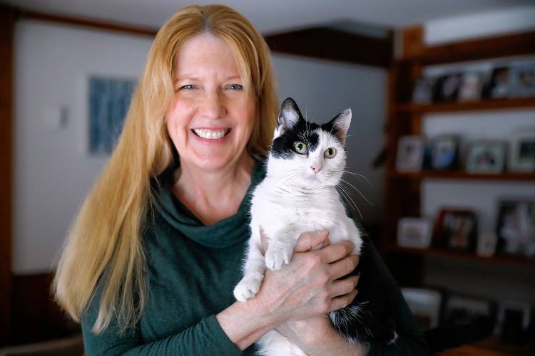 Rehome with Love founder and owner of Joyful Pets Rescue Lauren McCarron holds Cookie, one of the cats in her care looking to be rehomed, at her home in Wendell.