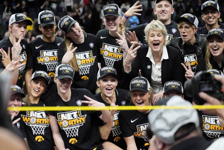 Iowa head coach Lisa Bluder and players pose for a team photo after defeating LSU in an Elite Eight round college basketball game during the NCAA Tournament, Monday, April 1, 2024, in Albany, N.Y. (AP Photo/Mary Altaffer)