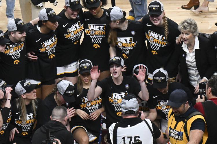 Iowa guard Caitlin Clark, center, poses with teammates for a photo after Iowa defeated LSU in an Elite Eight round college basketball game during the NCAA Tournament, Monday, April 1, 2024, in Albany, N.Y. (AP Photo/Hans Pennink)
