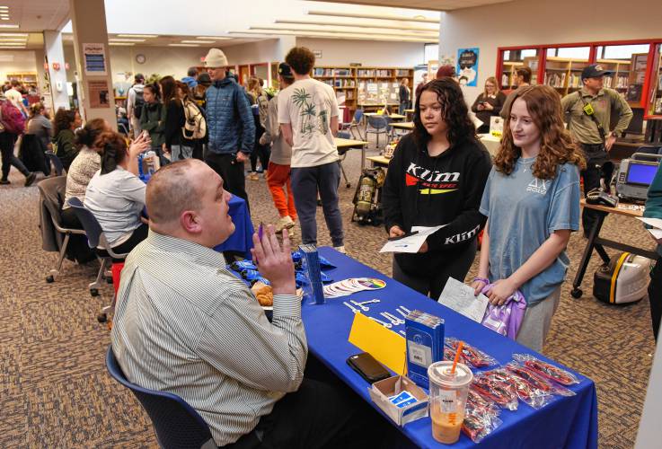 Cole Courtemanche of Baystate Health talks with Frontier Regional School students Kesenia Rivera and Autumn Casagrande at a career fair at the school on Wednesday.