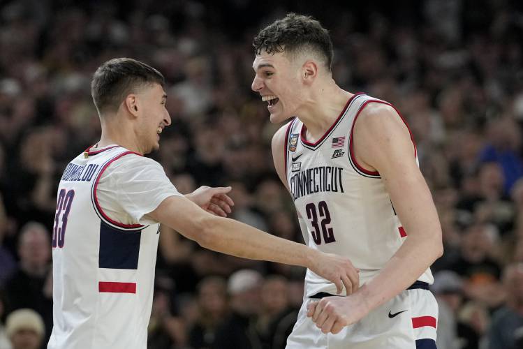 UConn center Donovan Clingan (32) celebrates with guard Apostolos Roumoglou (33) after their win against Purdue in the NCAA college Final Four championship basketball game, Monday, April 8, 2024, in Glendale, Ariz. (AP Photo/David J. Phillip)