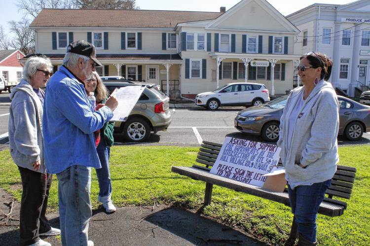 Matthew Baj signs a petition organized by Patricia Taylor, right, to have the Massachusetts Department of Transportation look at safety concerns regarding the intersection of Routes 5 and 10, Mill Village Road and North Main Street in Deerfield.
