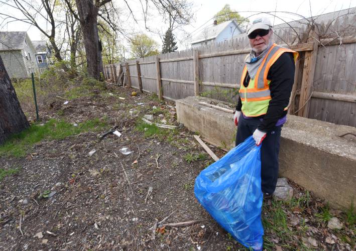 David Boles cleans up a vacant lot on Wells Street in Greenfield in April 2021. Greenfield is the site of a citywide cleanup, with blue trash bags available for anyone willing to pick up litter.