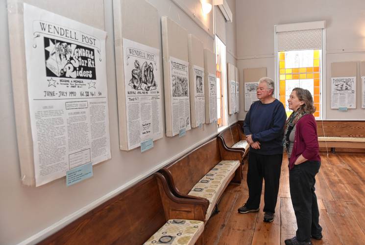 Jerry Barilla, a Friends of the Wendell Meetinghouse volunteer and former board member, and current member Debbie Lynangale view enlarged copies of the Wendell Post that are on display at the Wendell Meetinghouse. The enlarged front pages will be available for viewing on Saturday at the reception and community dinner planned by the Friends of the Wendell Meetinghouse and No Assault & Batteries, a local group formed last year in opposition to a proposed battery storage facility.