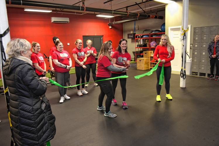 Greenfield Mayor Ginny Desorgher and Franklin County Chamber of Commerce Executive Director Jessye Deane hold the ribbon being cut by Common Ground Fitness Center co-owners Jamie Roberts and Nadya Beaudoin during their grand reopening celebration at 369 Federal St. in Greenfield on Wednesday.