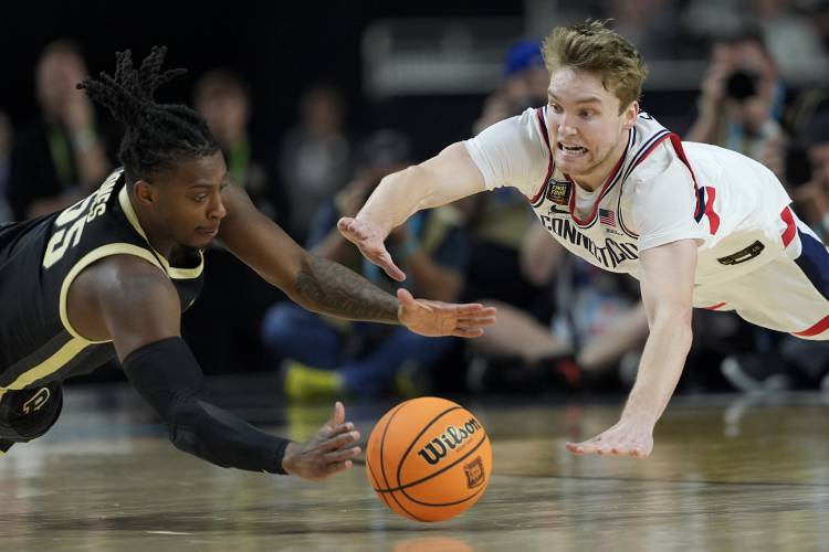 Purdue guard Lance Jones (55) vies for the ball with UConn guard Cam Spencer (12) during the second half of the NCAA college Final Four championship basketball game, Monday, April 8, 2024, in Glendale, Ariz. (AP Photo/David J. Phillip)