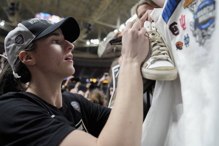 Iowa guard Caitlin Clark (22) signs autographs for fans after Iowa defeated LSU in an Elite Eight round college basketball game during the NCAA Tournament, Monday, April 1, 2024, in Albany, N.Y. (AP Photo/Mary Altaffer)