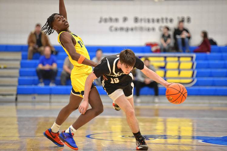 Pioneer’s Brayden Thayer dribbles around a New Mission defender in the MIAA Division 5 boys basketball state semifinal game at Worcester State University on Wednesday.