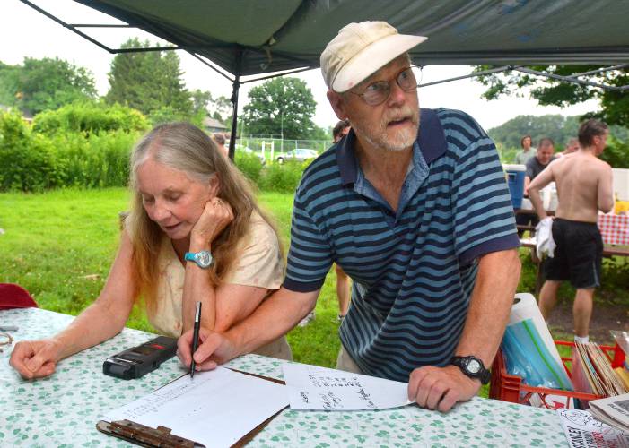 Sue and Don Grant record results during a past Sugarloaf Mountain Athletic Club 5K race at Northampton Community Gardens. 