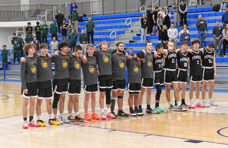 The Pioneer boys basketball team stands during the anthem before playing New Mission in the MIAA Division 5 boys basketball state semifinal game at Worcester State University earlier this month.
