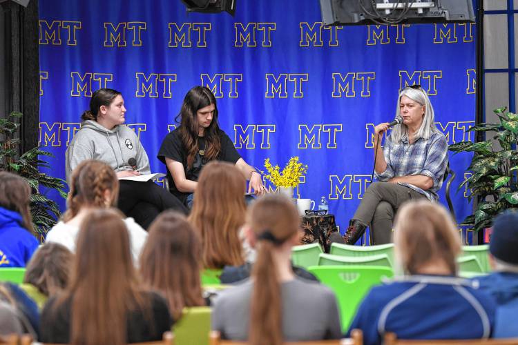 Author Lydia Millet speaks to students in the Mohawk Trail Regional School library on Tuesday. Students hosts from left are Sophia Goodnow and Eliza Crowell. Millet’s books include “A Children’s Bible” and “Dinosaurs.”