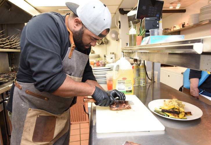 Chef Tomii Mathews of Watershed restaurant in Montague Center slices a skirt steak served with garlic mashed potatoes, fresh zucchini and summer squash in July 2022. After nearly two years in business, the restaurant will close on Dec. 2.