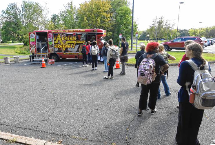 Students line up in the parking lot of Greenfield Community College on Wednesday for free ice cream from Ice Cream Emergency. After more than a decade of declining enrollment, the number of students at GCC increased this fall by the largest percentage since 2010, school officials say.