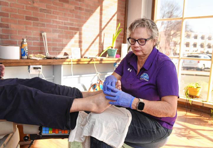 Registered nurse Kate Clayton-Jones works with a client at FootCare by Nurses’ new space at 40 School St. in Greenfield.