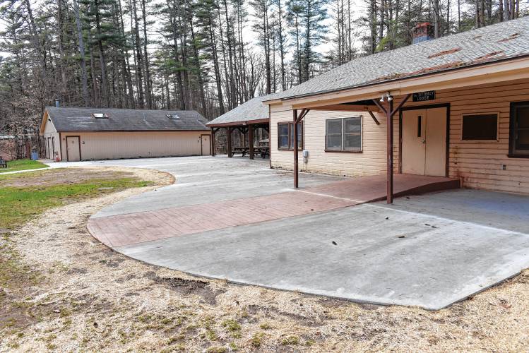 A newly poured apron of concrete connects the lodge and covered area with the bathhouse at Camp Apex in Shelburne. 