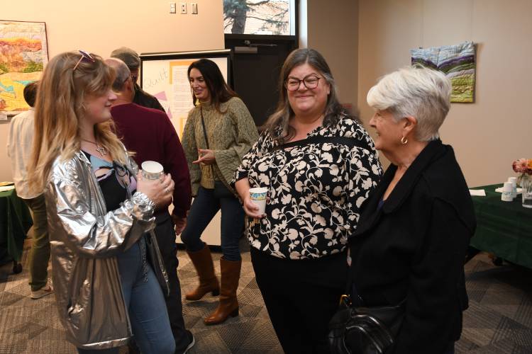 Carole Collins, center, departing energy and sustainability director for Greenfield, is celebrated for her service at a gathering in a meeting room at the Greenfield Public Library in October. At left is her daughter, Morgan Trenholm, and at right is Greenfield Mayor Roxann Wedegartner.