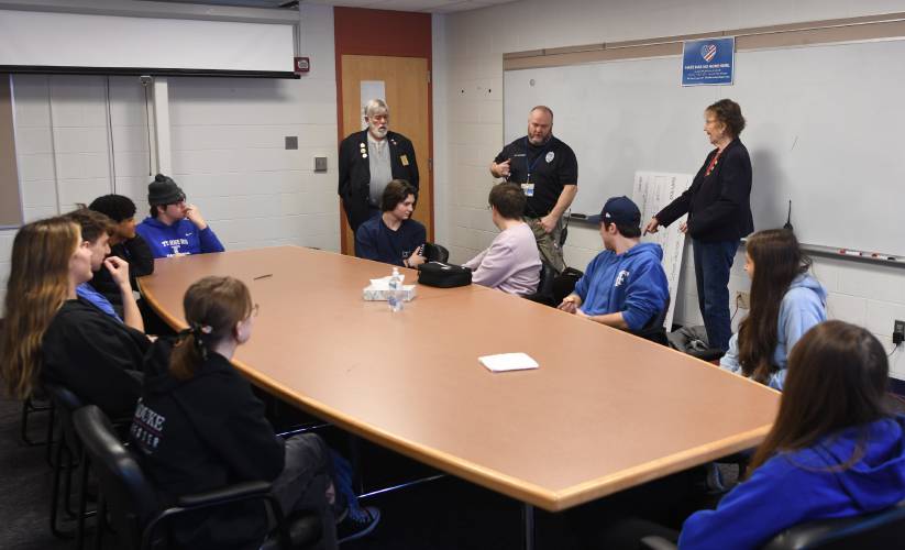 Steve Dacyczyn, left, and his wife Judy Dacyczyn, right, both of the Montague Elks Lodge, and Turners Falls School Resource Officer Dan Miner, center, meet with the Athletic Leadership Council at Turners Falls High School on Monday to accept a $2,500 donation from the Elks that the students will use to support the Helping Hands charity.