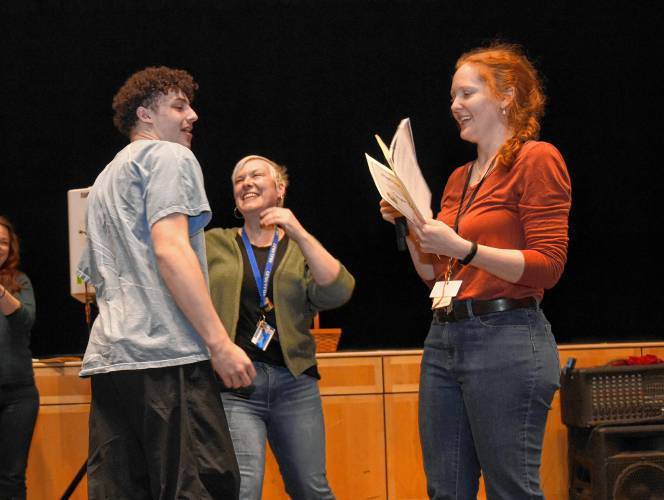 Turners Falls High School history teacher David Smith receives the McGraw Uplift Award from teacher Jessica Vachula-Curtis during an assembly at the school Friday morning.