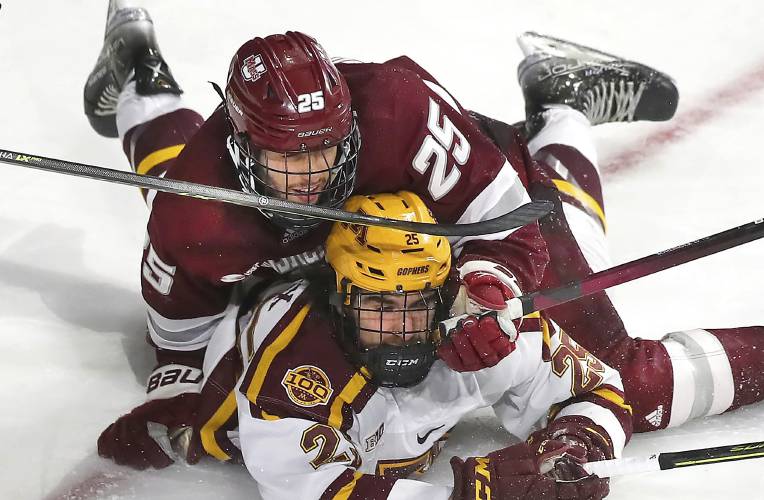 UMass defenseman Aaron Bohlinger (25) (top) collides with Minnesota’s Jack Perbix during NCAA Tournament action in March, 2022. Bohlinger was named a captain for the upcoming UMass hockey season, along with Ryan Ufko.