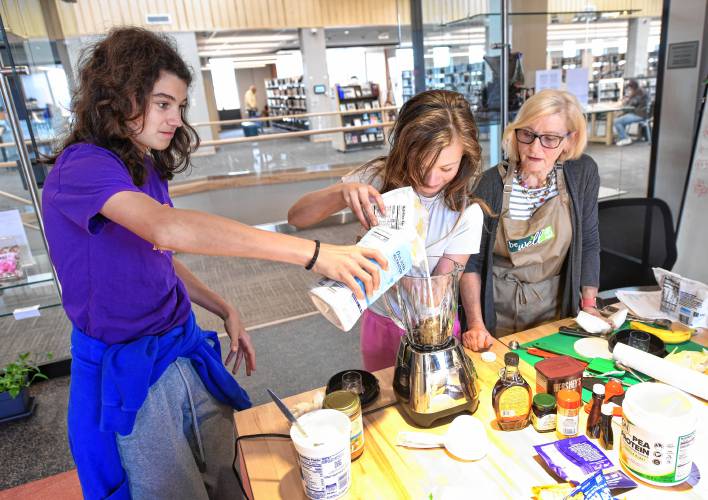 Hendrick Carew, 14, and Amy Reynolds, 10, are guided by dietitian Kathy Jordan during a smoothie-making class emphasizing good nutrition on Tuesday at the Greenfield Public Library. The event was funded by Big Y supermarket.