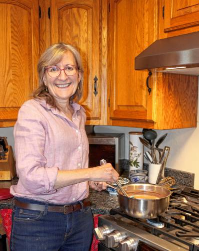 Peggy Travers stirs Goat-Milk Chocolate Pudding. She says she routinely doubles or triples this recipe; Grahame loves it.