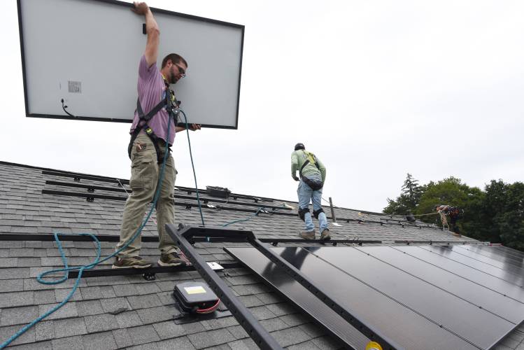 PV Squared workers install solar panels in Greenfield. The Ashfield Energy Committee will host a public forum next week to discuss expanding solar power in town.