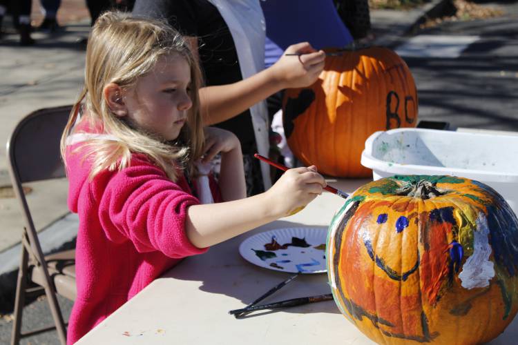 Collette Schaentzler, of Heath, paints a pumpkin at the Great Falls Festival in Turners Falls in 2021. Although 2022 marked the final year of the traditional Great Falls Festival, a new group of  organizers has banded together to put on a unique version that pays homage to its predecessor on Oct. 21.