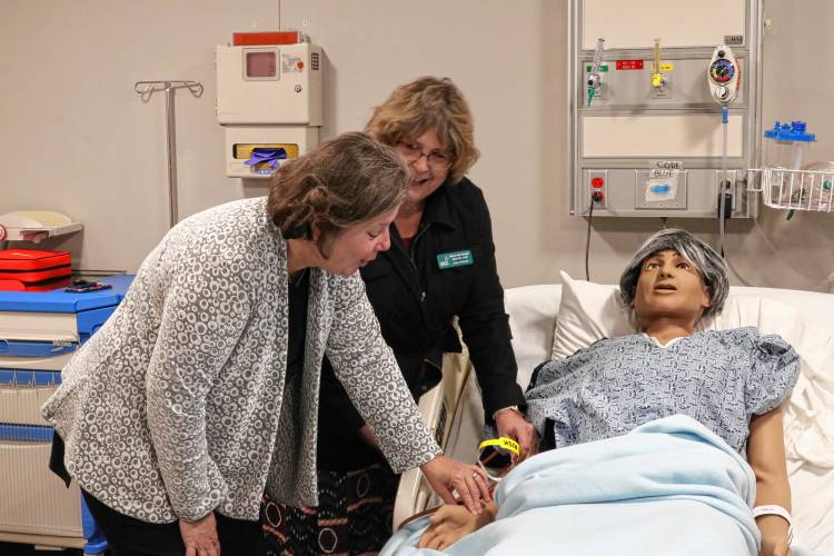 Led by Dean of Nursing Melanie Zamojski, Sen. Jo Comerford, D-Northampton, checks the pulse of a “patient” in a nursing simulation lab.