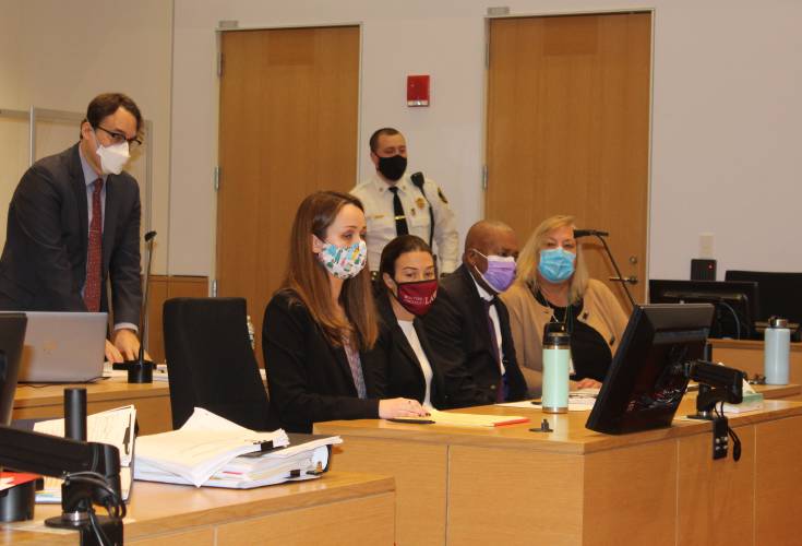 Elvio J. Marrero, center, wearing a purple face mask, is flanked by his defense team, from left to right, attorney Ira Gant, Lauren Jacobs, Charlotte Whitmore and a Spanish language interpreter, during a court hearing in 2021. Marrero had his murder conviction overturned on Thursday.