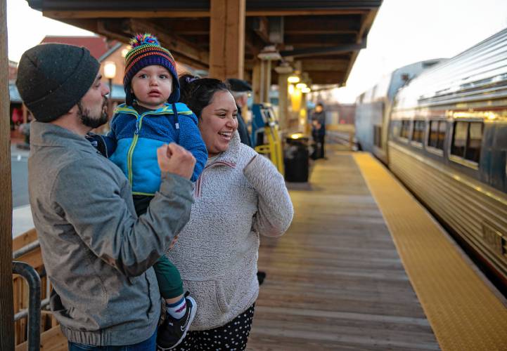 Cam Brown holds his son, Dominic Brown, with his wife and Dominic’s mother, Ximena Cruz de Brown, as they wait for Cruz de Brown’s parents to arrive by train at the Northampton station.