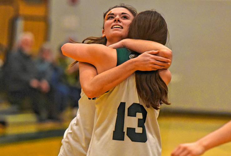 Greenfield’s Amber Bergeron (12) hugs her younger sister and teammate, Tayler Bergeron (13), after sinking a free throw in the fourth quarter for the 1,000th point of her career against Drury on Thursday at Nichols Gymnasium in Greenfield.