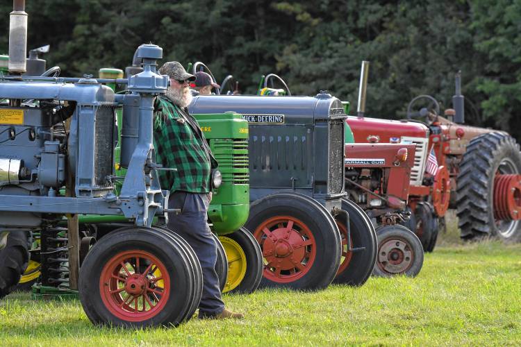 Wes Brothers of Monroe watches The Antique Tractor Parade at the Heath Fair on Friday night.