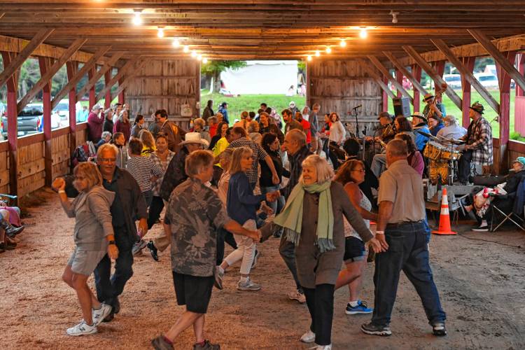 Doug Wilkins called square dances backed up by the Fall Town String Band at the Heath Fair on Friday night.