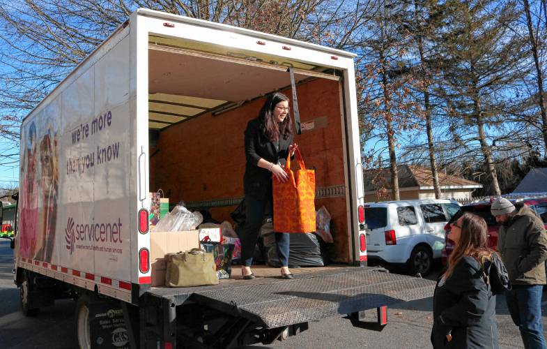 ServiceNet Director of Communications & Development Amy Diehl unloads donations for the Christmas toy drive for families in the Greenfield shelter system in the Days Inn parking lot on Friday. 