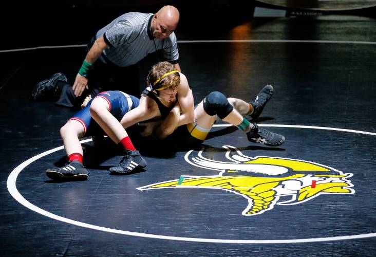 Smith Vocational’s Evan Latour works to pin Frontier’s Zach Brown while competing in the 138-pound weight class Wednesday night in Northampton. 