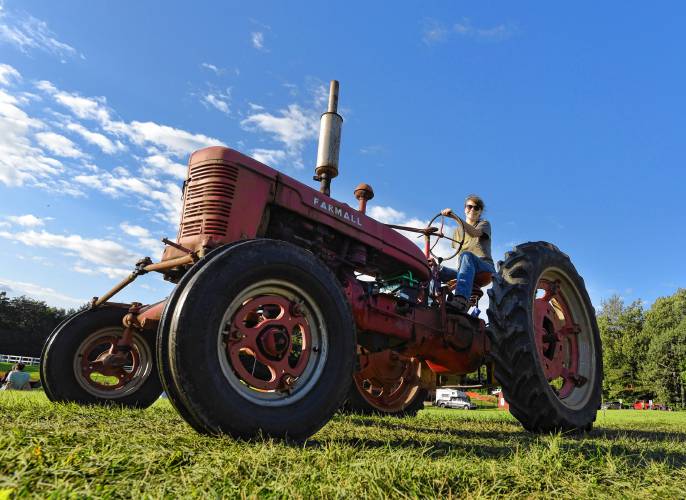 Gwyn Clark of Heath drives an old Farmall tractor in the Antique Tractor Parade at the Heath Fair on Friday night.
