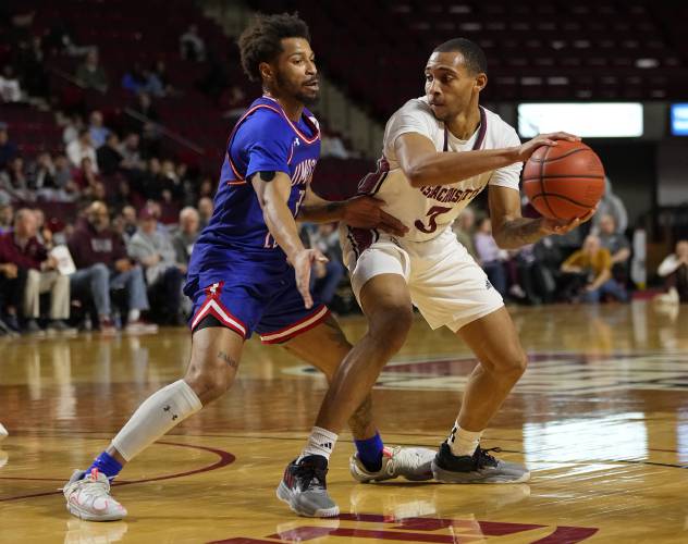 UMass’ Rahsool Diggins (3), right, looks to make a pass against UMass Lowell during the Minutemen’s 91-77 victory on Saturday at the Mullins Center in Amherst.