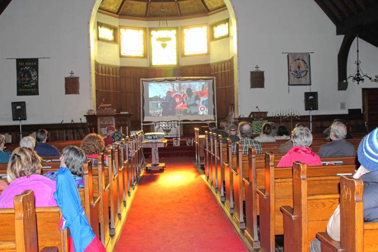 People at All Souls Church watch the National Day of Mourning livestream from Plymouth.