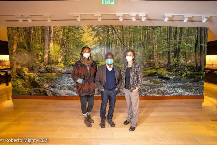 A mural honoring the legacy of the Nipmuc people who lived on and cared for the land that is now Harvard Forest was unveiled at the Fisher Museum in 2021. From left are Nia Holley, who was involved in creating the mural, photographer Roberto Mighty, and Clarisse Hart, director of outreach and education for Harvard Forest and Fisher Museum director.