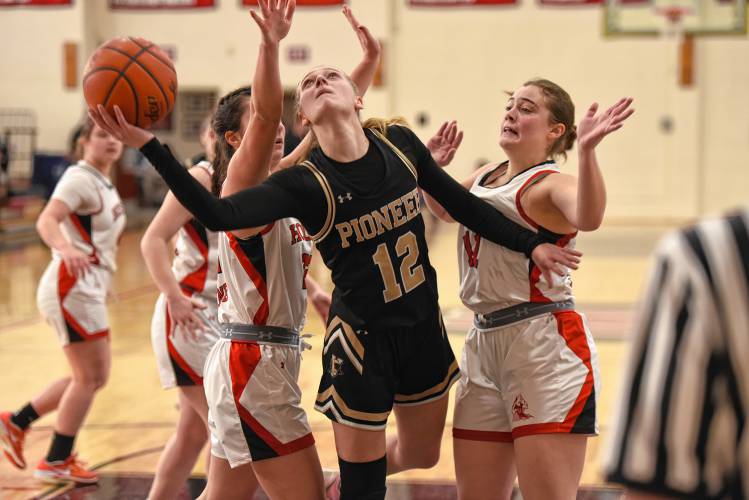 Pioneer’s Hailey Ring (12) goes the basket while defended by Hoosac Valley’s Abby Scialabba (22), left, and Hanna Shea (11) during the Panthers’ 57-35 loss in the Western Mass. Class D championship game on Saturday at Westfield High School.