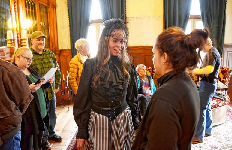 Revival Wheeler Mansion owner Cynthia Butler talks with visitors during an open house on Monday.