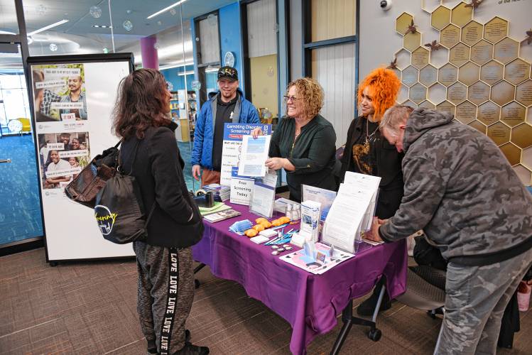 Member Patrick Bucier, Program Director Abbi Cushing and worker Sarah Rashad, all with The RECOVER Project, speak with visitors about gambling addiction at the Greenfield Public Library on Tuesday, which marked Gambling Disorder Screening Day