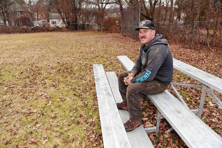 Robert A. Woodard sits on the bleachers at Spear Field in Orange, which has not been used for organized play in 10 to 15 years. Athol-Orange Chuck Stone Baseball/Softball, of which Woodard is president, has decided to renovate Spear Field for softball players in time for opening day on May 4.