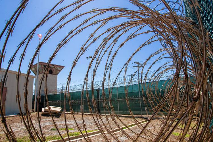 In this April 17, 2019, photo, reviewed by U.S. military officials, the control tower is seen through the razor wire inside the Camp VI detention facility in Guantanamo Bay Naval Base, Cuba.